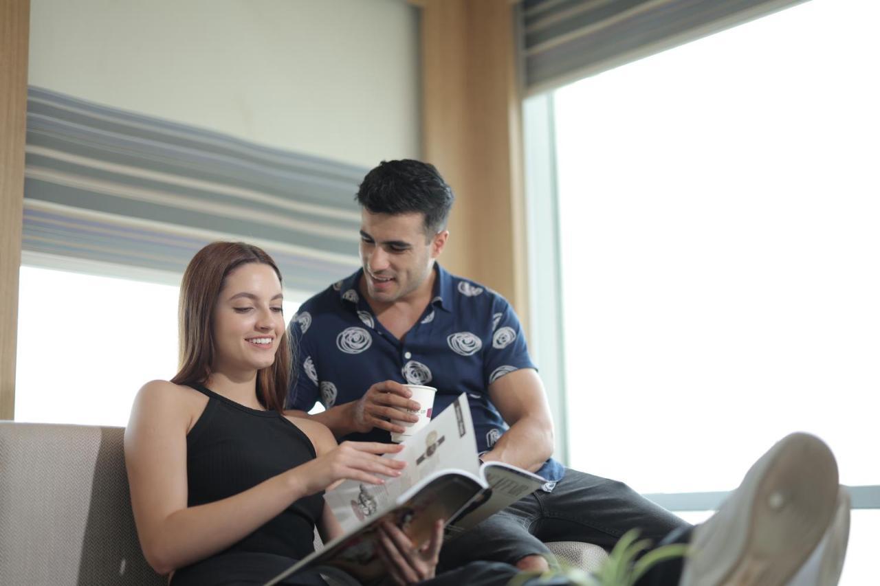 Aloft New Delhi Aerocity Buitenkant foto A couple reading a magazine